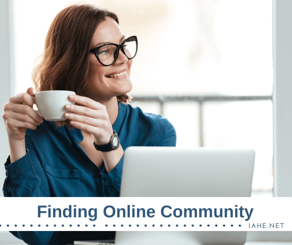 A woman wearing glasses and a blue shirt holds a coffee cup while smiling and looking away from her laptop. The text at the bottom of the image reads "Finding Online Community" with "IAHE.NET" in the corner.